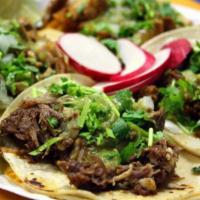Taco · Soft corn tortillas with choice of meat, topped with cilantro and chopped onions.