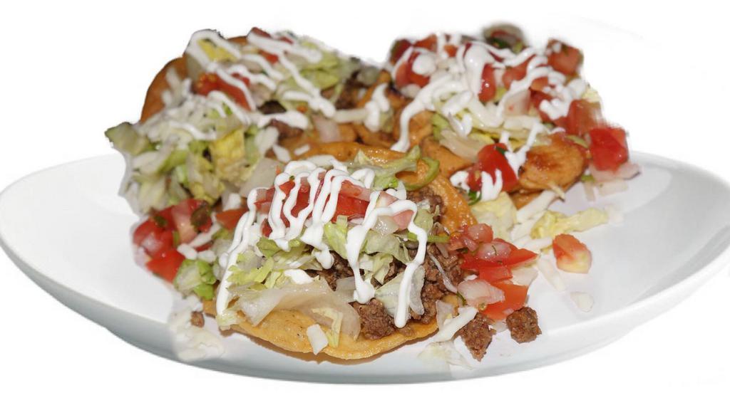Tostadas · A hard shell corn tortilla topped with beans choice of meat, lettuce, cheese, sour cream, pico and guacamole.