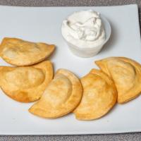 Pierogies · Potato and cheese pierogies with a side of sour cream.