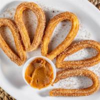 Churros  · Accompanied by a side of dulce de  leche
portion with 6 churros