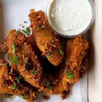 Chili Crisp Wings · Breaded and fried wings in our house chili crisp sauce.. Contains gluten, alliums, and dairy.