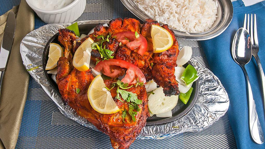 Chicken Tandoori · Spring chicken marinated in fresh spices and lemon, then barbequed over flaming charcoal in the tandoor.