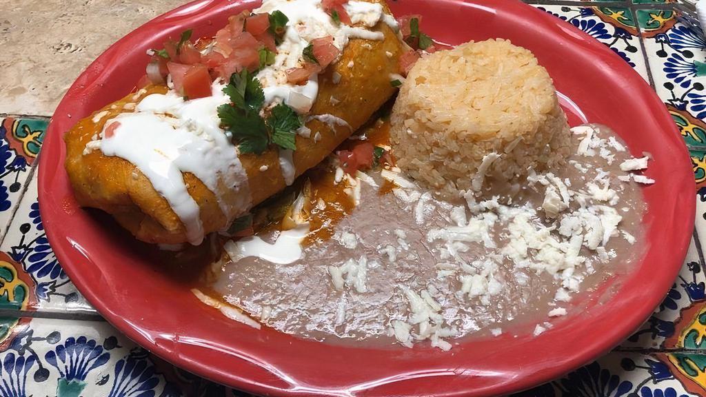 Chimichangas · Choice of meat, choice of sauce, stuffed with Oaxaca cheese, served with rice, refried beans, topped with Pico de Gallo, lettuce, sour cream, and queso fresco.