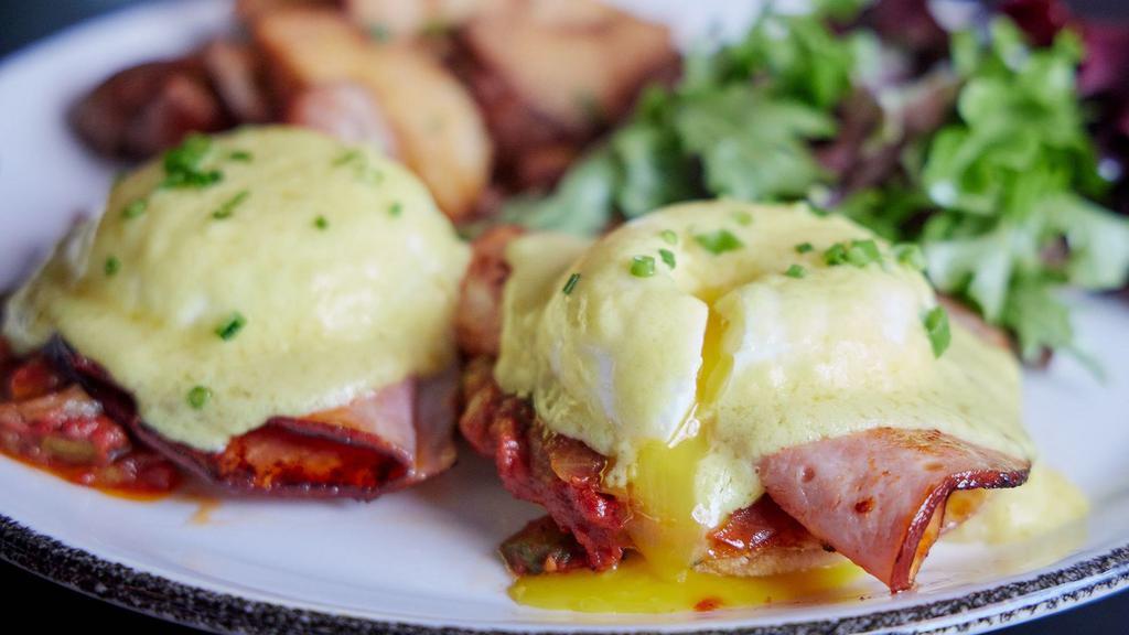 Frenchie Benny · smoked ham, caramelized onion, gruyere, tomato jam, english muffin, two poached eggs, hollandaise, served with home fries and greens