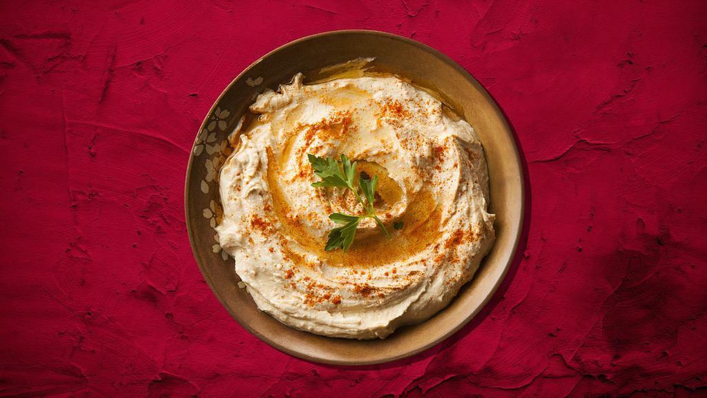 Hummus Appetizer · A blend of chickpeas and our signature tahini sauce, cold dip is then drizzled in olive oil topped with tomatoes and onions and served with our warm fresh pita.