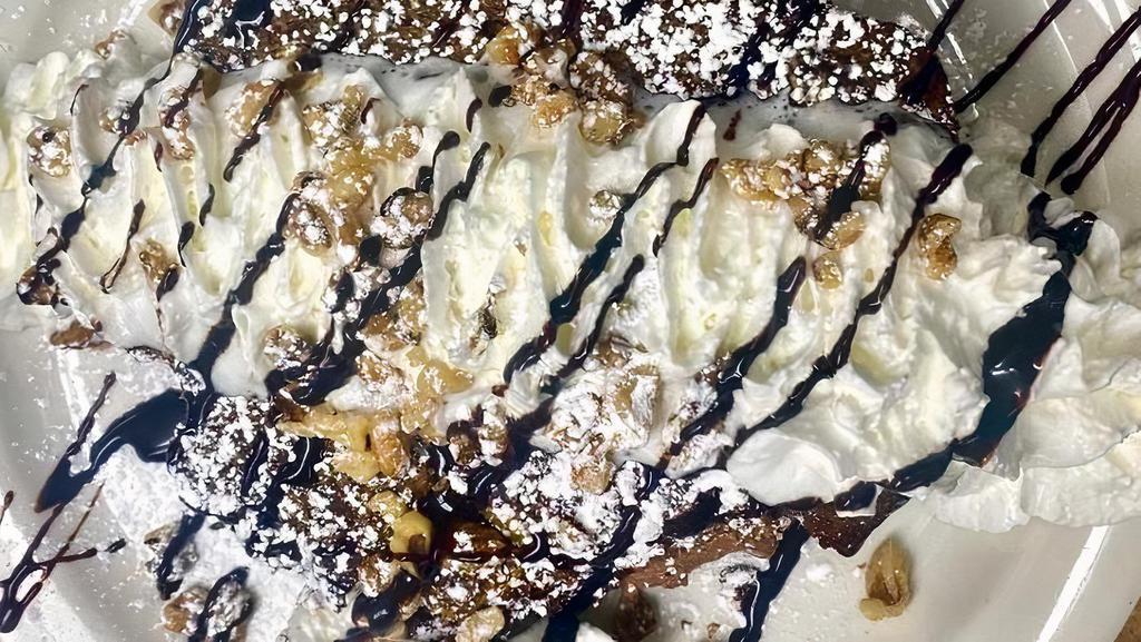 Banana Bread Stuffed French Toast · Delicious homemade banana bread, dipped in French toast batter, stuffed with creamy Nutella & cream cheese mixture. topped with whipped cream, walnuts and chocolate sauce