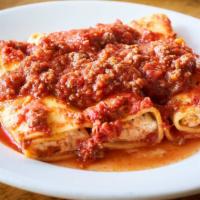 Manicotti Al Sugo Di Carne · Baked ricotta stuffed pasta with meat sauce.