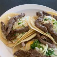 Huevos Rancheros Con Bistec · Three tacos filled with refried beans, eggs, onions, cilantro, cheese and steak.