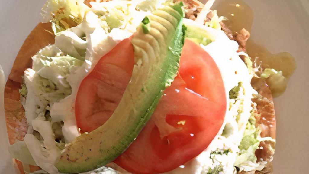 Tostada · Fried tortilla shell with refried beans, meat of choice, lettuce tomato, sour cream, cheese and avocado.