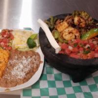 Molcajete Ranchero · Grilled nopal with grilled chicken, steak shrimp, chorizo, carnitas,  onion, and peppers, se...