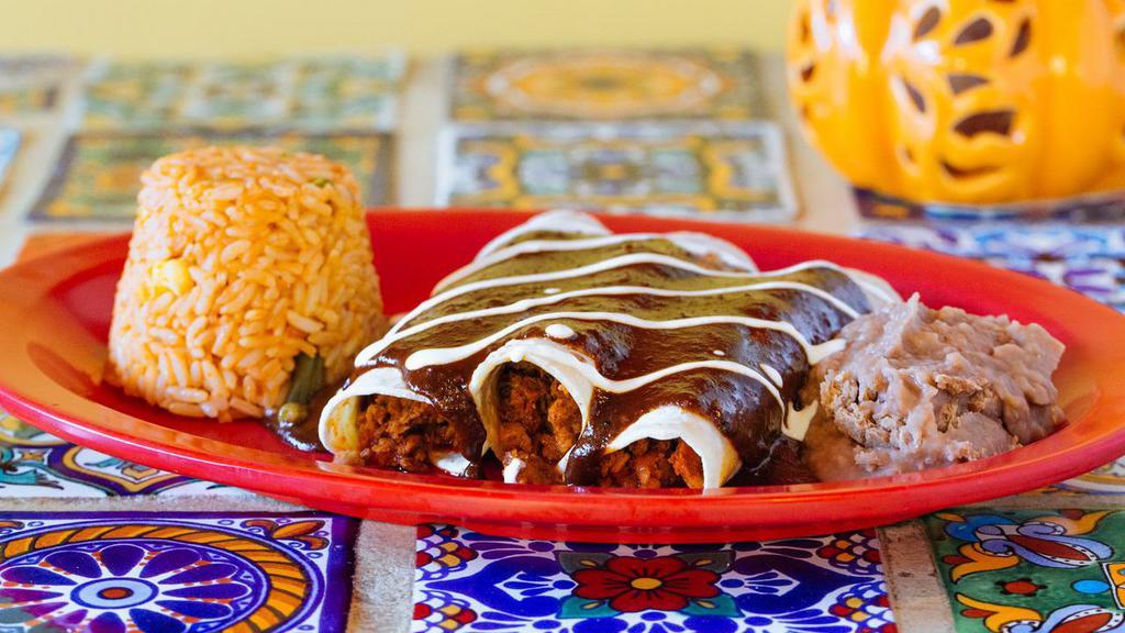 Enchiladas · Three soft corn tortillas topped with cheese, sour cream and the sauce or your choice mole or tomatillo. Served with rice and beans.