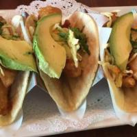Baja Fish Tacos · Golden fried tilapia, stuffed with coleslaw, tomatillo sauce, pickled red onions, in a flour...