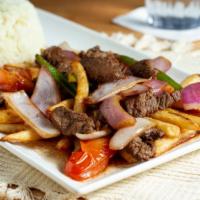 Lomo Saltado · Peruvian style sirloin tips sauteed with onions, tomatoes, cilantro, jalapenos, served over ...