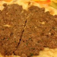 Kafta Manakeesh · Mildly spiced ground lamb and beef mixed with parsley and onions. Topped with pickles and se...