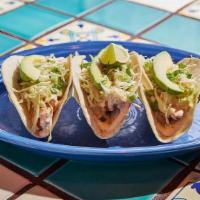 Tacos Del Mar · Baja style, beer-battered fish, scallions, orange slaw, three pepper sauce and avocado, on s...