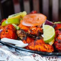 Tandoori Chicken · Chicken leg quarters marinated in yogurt, fresh spices and lemon juice then barbecued in the...