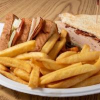 Turkey Club · Served with fries, pickles, lettuce, tomato, mayo, and bacon.
