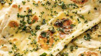 Garlic Naan · Bread topped with fresh minced garlic and herbs.