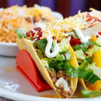 Crunchy Beef Tacos · Four crunchy corn tortillas, house-made taco beef, cheese, lettuce, tomato, and Mexican crèm...