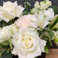 Serene Escape · Gorgeous arrangement of white blooms adorned and textural foliages designed in a stylish bla...