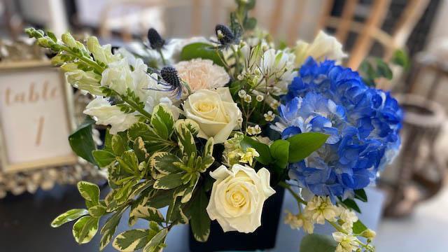 Tranquil Moment · Stunning arrangement mix of premium white and blue blooms and foliages designed in a stylish black vase. Blooms and foliages will vary weekly based on season and availability.