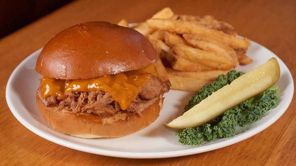 Pulled Pork Sandwich · Slow-roasted, hand-pulled pork smothered in our own BBQ sauce, topped with melted cheddar cheese and served on a toasted brioche roll.