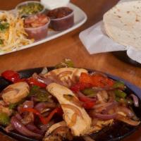 Fajitas · Grilled strips of marinated steak, chicken, or shrimp, served sizzling hot with bell peppers...