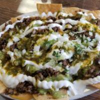 Super Nachos · Choice of meat, guacamole, sour cream, refried beans and nacho cheese.
