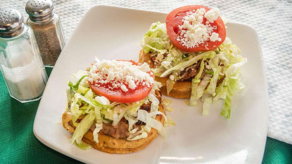 Sope (Single) · Small handmade fried tortilla, choice of meat, refried beans, lettuce, tomato, cheese, tomato sauce