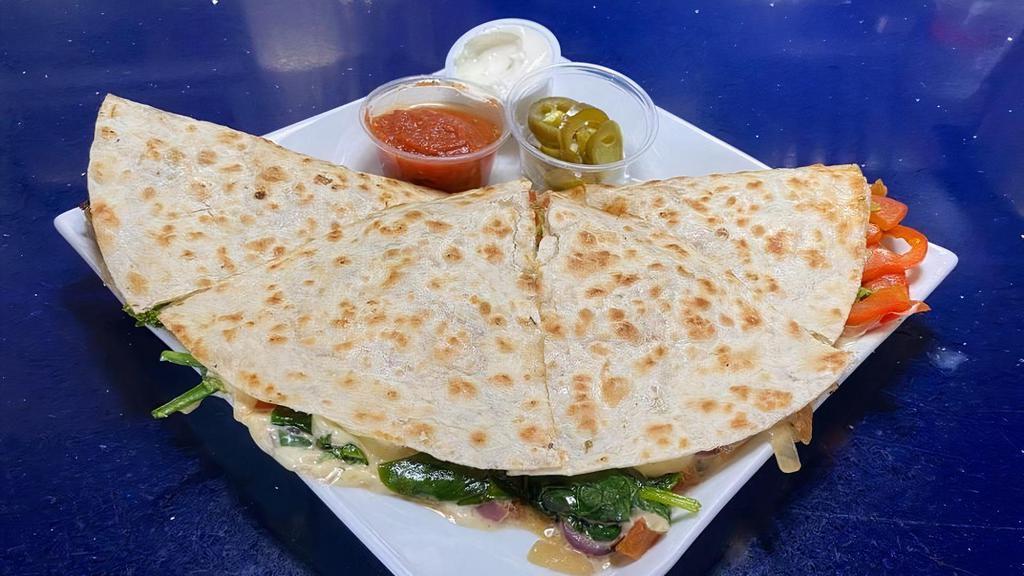 Online Veggie Quesadilla · Grilled flour tortilla pressed with grilled seasonal veggies and melted cheddar cheese inside. Served with homemade salsa, jalapeños, and sour cream on the side.