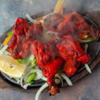 Tandoori Chicken · Chicken marinated with yogurt, ginger, lemon juice and ground spices cooked in a tandoor.