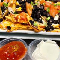 Nachos · Organic local corn chips, refried beans, tomatoes, green onions, and mozzarella/cheddar blen...