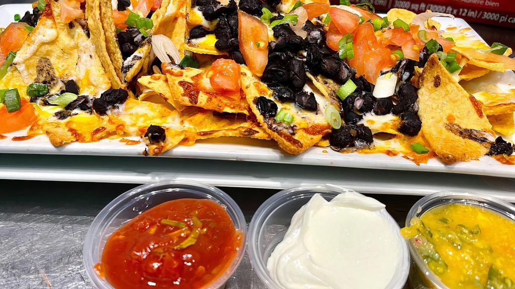 Nachos · Organic local corn chips, refried beans, tomatoes, green onions, and mozzarella/cheddar blend of cheeses with sour cream, red salsa, and mango salsa. Add organic chicken or avocado for an extra price.