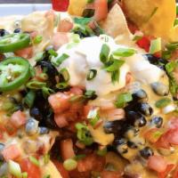 Nachos · Baked tortilla chips topped with cheese sauce, black beans, tomatoes & jalapeno peppers, sal...