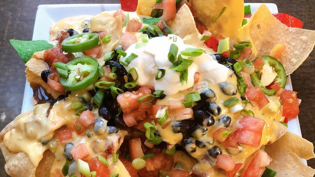 Nachos · Baked tortilla chips topped with cheese sauce, black beans, tomatoes & jalapeno peppers, salsa & sour cream.