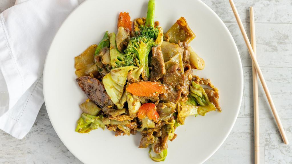 Pad Sen With Curry · homemade flat noodles stir fried with curry powder, eggs, carrots, cabbage, onions and broccoli mixed.
