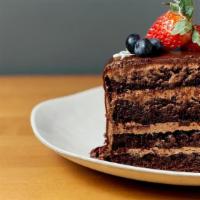 Slice Midnight Chocolate Cake · deep, dark devil’s food cake filled with a silky milk chocolate buttercream and finished wit...