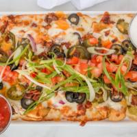 Nacho Potato Skins · Fresh potato nachos loaded with melted cheese, bacon crumbles, black olives, and pickled jal...