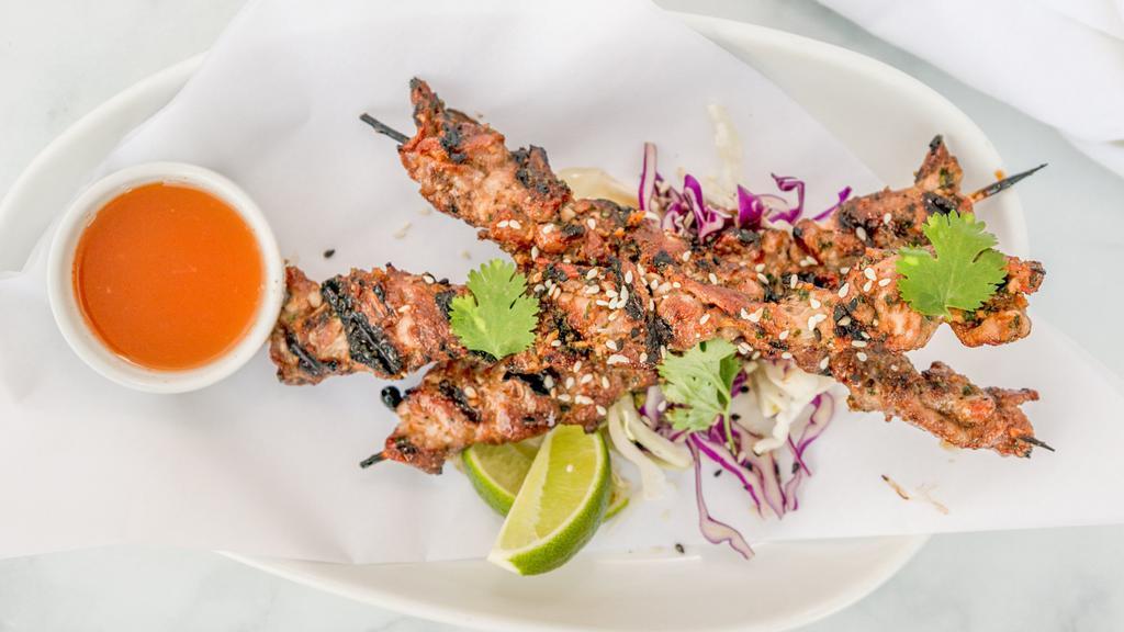 Phuket Pork Skewers · Charbroiled thai-style pork skewers served over cabbage salad with cilantro-lime vinaigrette and thai chili-vinegar dipping sauce.