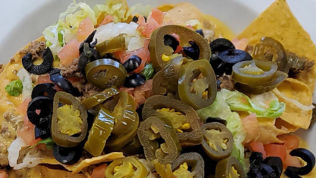 Nachos Supreme · Corn tortilla chips with your choice of meat: chicken, beef or pork carnitas. Topped with lettuce, diced tomatoes, black olives and jalapeños. Served with a side of salsa, guacamole and sour cream.