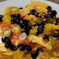Cheese Nachos · Corn tortilla chips topped with melted cheese, jalapeños, diced tomatoes and black olives. W...