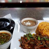 Birria De Chivo · Slow steamed goat with mild chile seasoning. Served with side of refried beans, corn tortill...