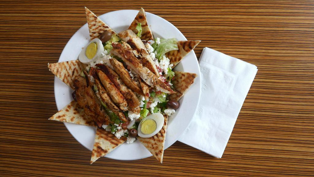 Greek Salad · Top menu item. Chopped greens, Kalamata olives, feta cheese, red onions, anchovies, cucumbers and tomatoes in red wine garlic oreganata vinaigrette.