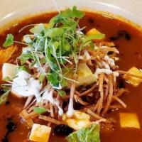 Sopa Azteca · Traditional Mexican soup with a blend of four chilies, served with pulled chicken, garnished...
