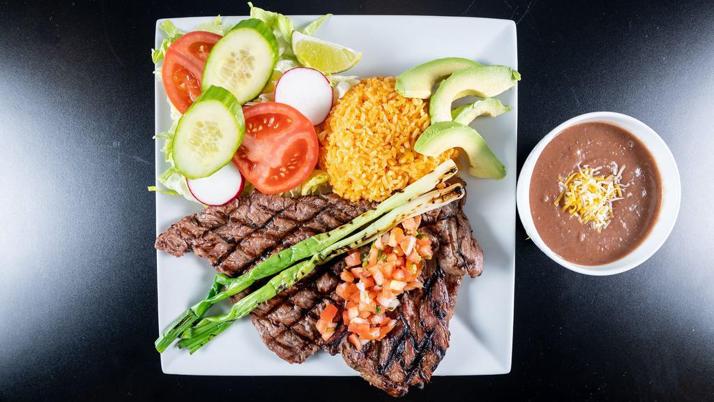 Carne Asada Dinner · Grilled sirloin steak, sliced thin, served with Mexican rice, refried beans, pico de gallo, sliced avocado, grilled scallions, and house salad with corn tortillas side.
