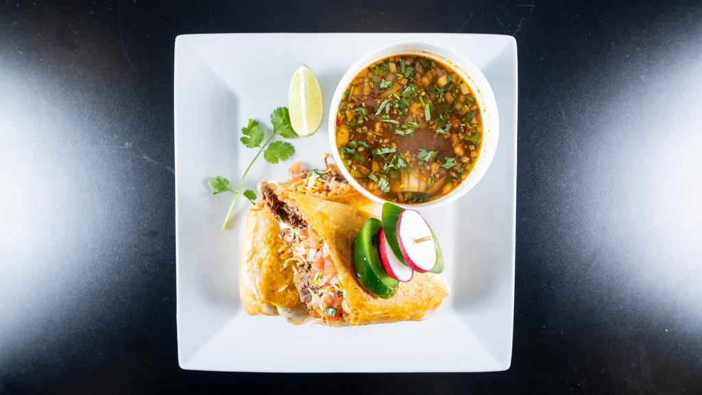 Birria Burrito · Large 12' flour tortilla filled with our famous marinated. Slow cooked short rib and ribeye birria Mexican rice, refried beans, pico de gallo. Three cheese blend guacamole - sour cream and onions - rich consomme on the side for dipping.