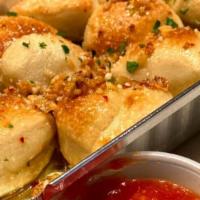 Garlic Knots · Fresh-baked with olive oil, fresh garlic, parsley & cheese, served with tomato sauce side