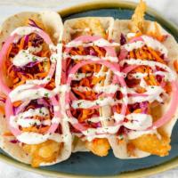 Fish Tacos · Crispy haddock, pickled onion, cabbage and carrot, white sauce.