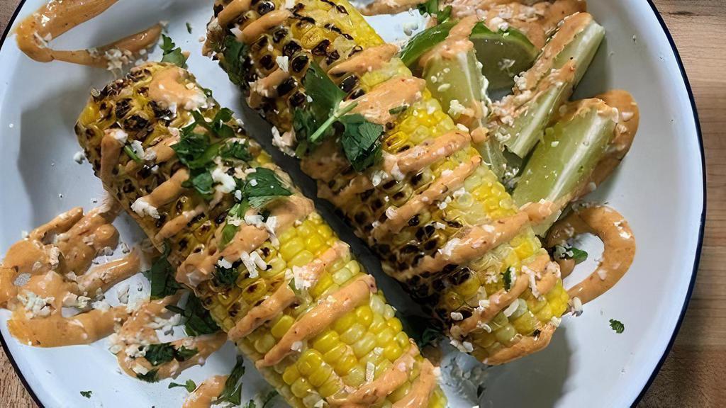 Vegan Grilled Elote · Grilled corn topped with vegan chipotle mayo, cilantro, lime