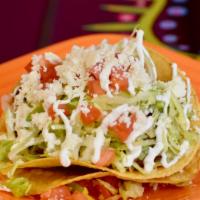 Tostada · One flat crispy corn tortilla topped with beans, your choice of filling, lettuce, tomatoes, ...